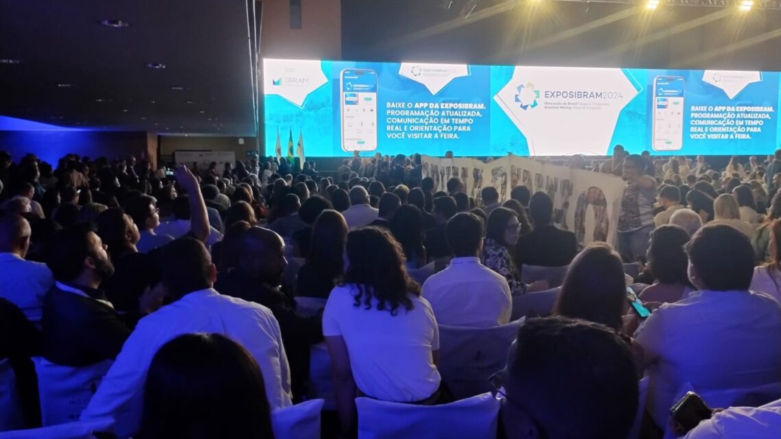 Familiares de vítimas de Brumadinho erguem bandeira de 5 metros em protesto na abertura da maior feira de mineração da América Latina